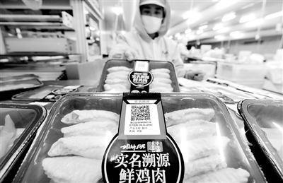 近日，在孟村回族自治县大成食品公司无菌生产车间，工人将可实名追溯产品的二维码“安心码”粘贴在肉鸡产品上。新华社发