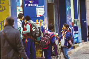 　　放学后，卫国路一士多店门口，不少小学生聚在此处吃零食。/组图由佛山日报记者王伟楠摄